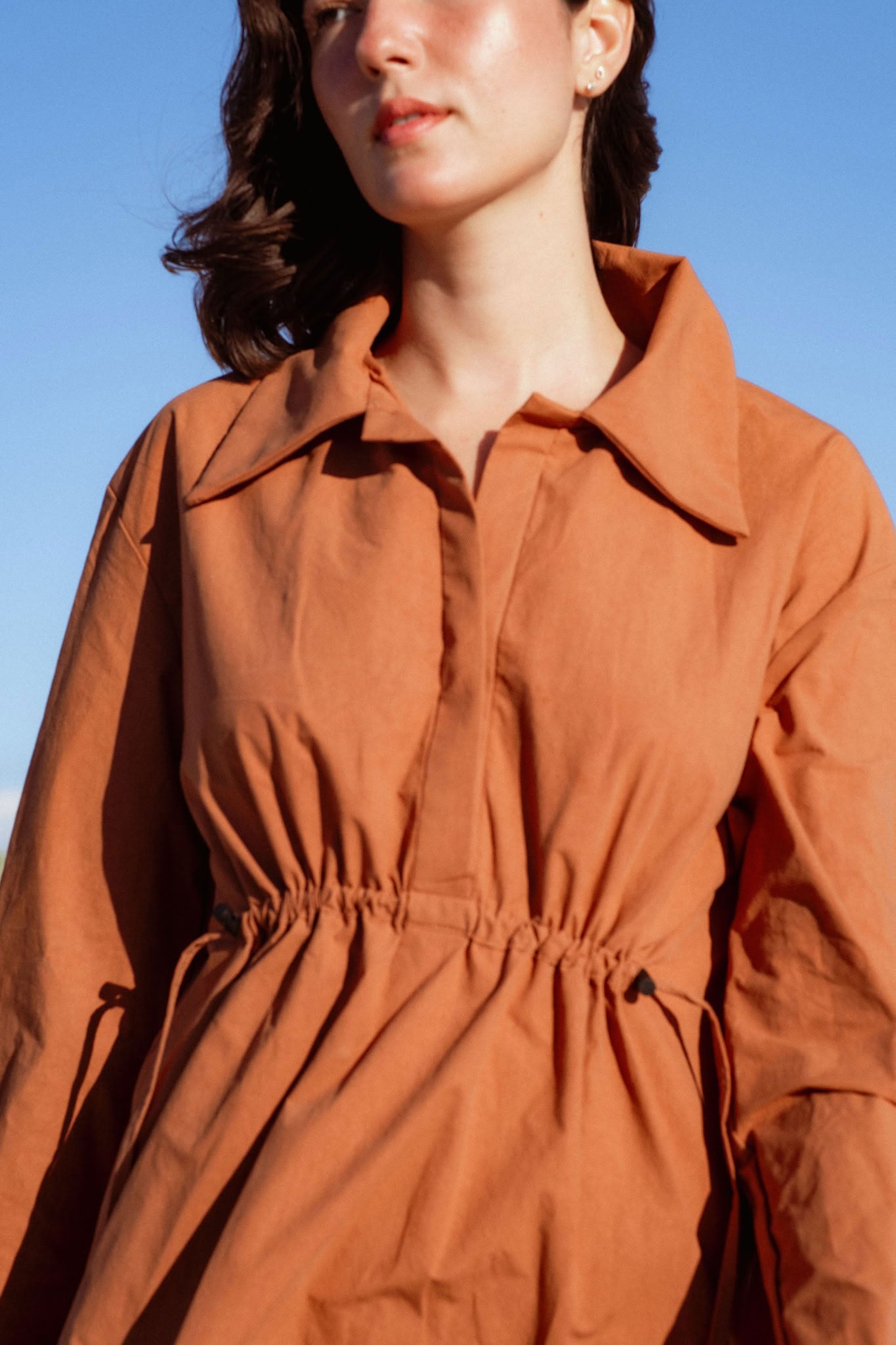 Vancouver Dress in Rust (Copper) cinched waist cotton shirt dress, side view - MAS Montréal