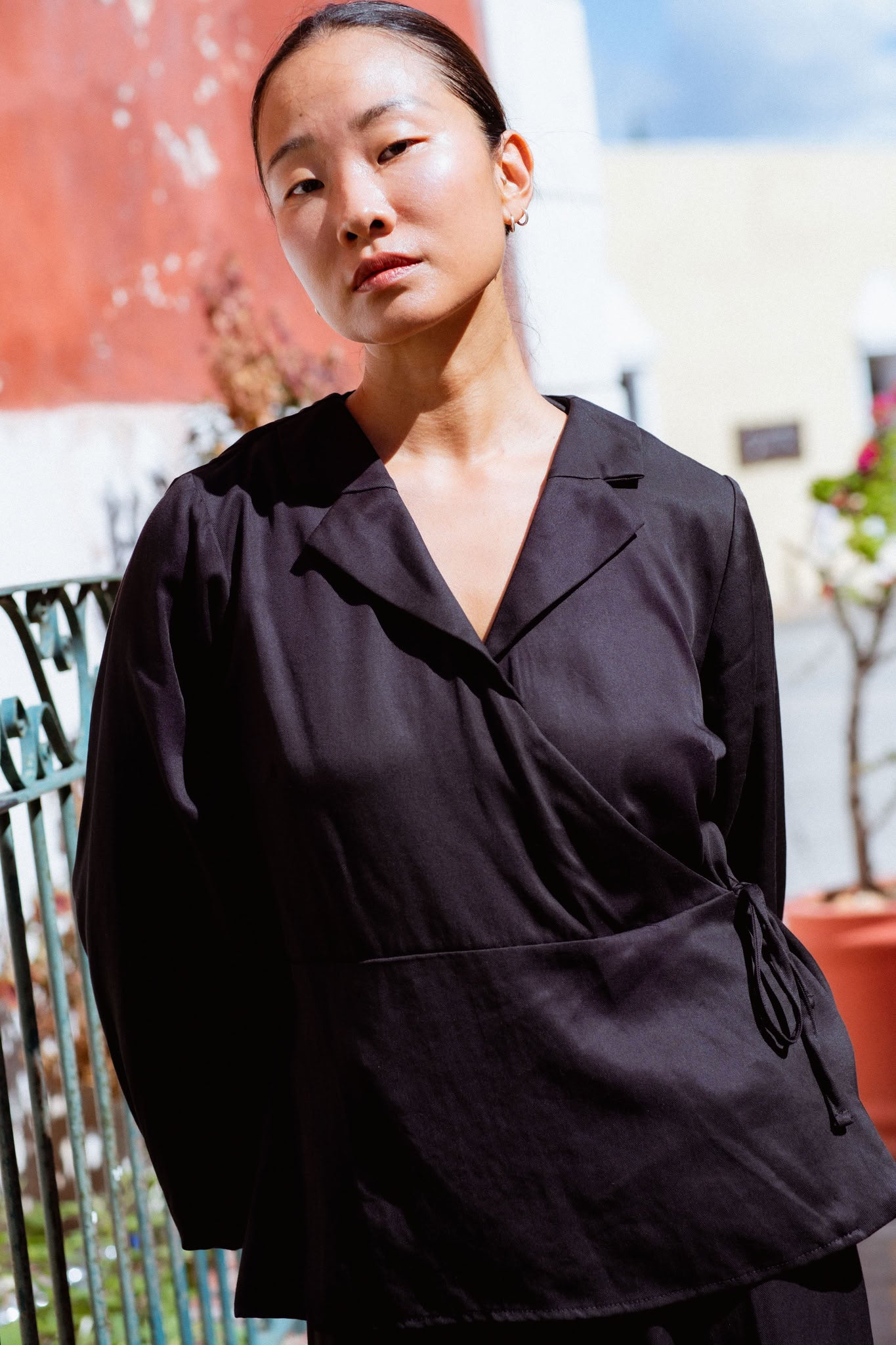Skelling Blouse in Black (Carbon) wrap-front lyocell blouse, worn - MAS Montréal
